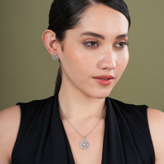 Woman wearing a necklace and earrings against a green background