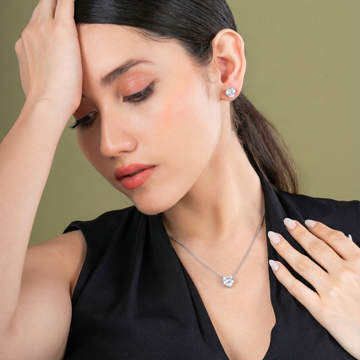 Woman wearing a necklace and earrings against a green background