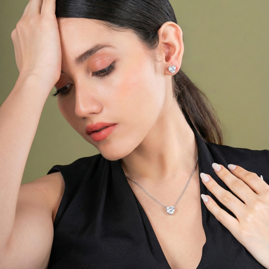 Woman wearing a necklace and earrings against a green background