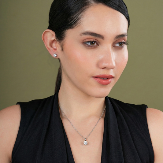 Woman wearing a necklace and earrings against a green background